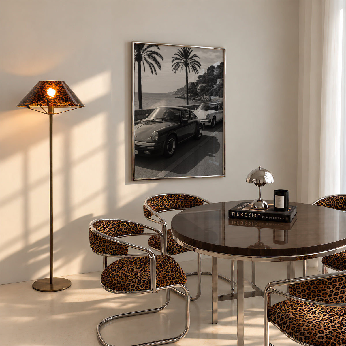 framed black and white French Riviera poster print hanging above table in dining room with cheetah accents