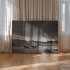 framed black and white Gods country wall art leaning against the wall on the floor