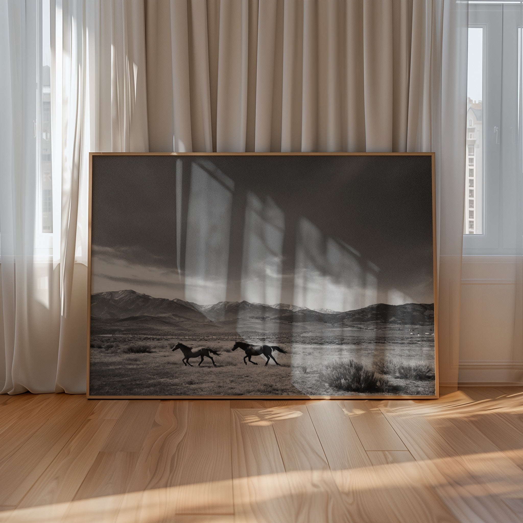 framed black and white Gods country wall art leaning against the wall on the floor