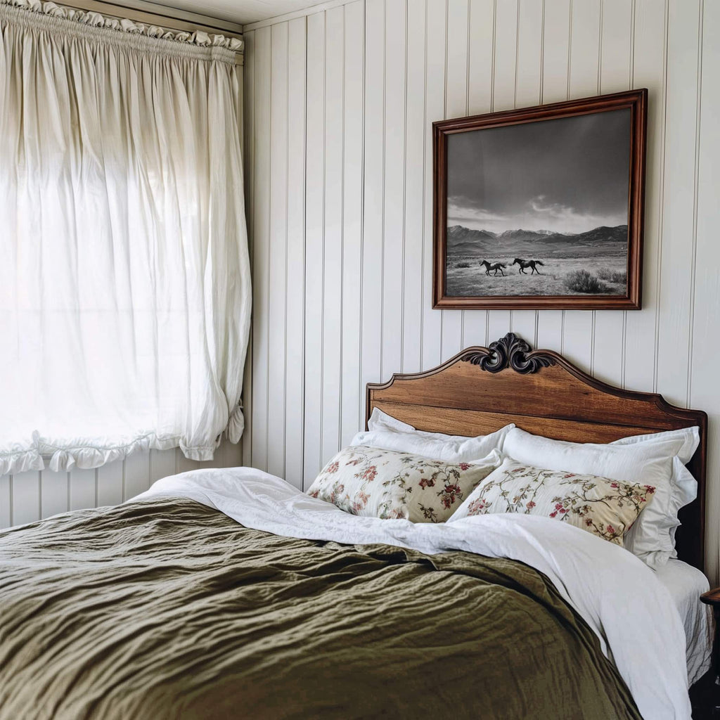 black and white framed western wall art hanging above bed in rustic bedroom