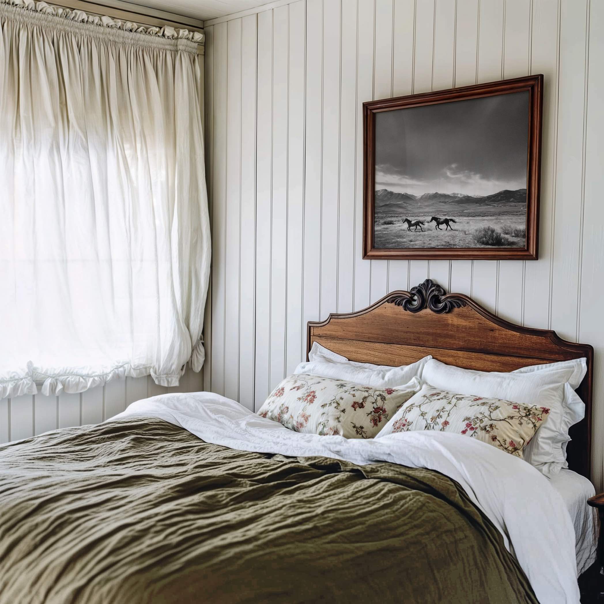 black and white framed western wall art hanging above bed in rustic bedroom