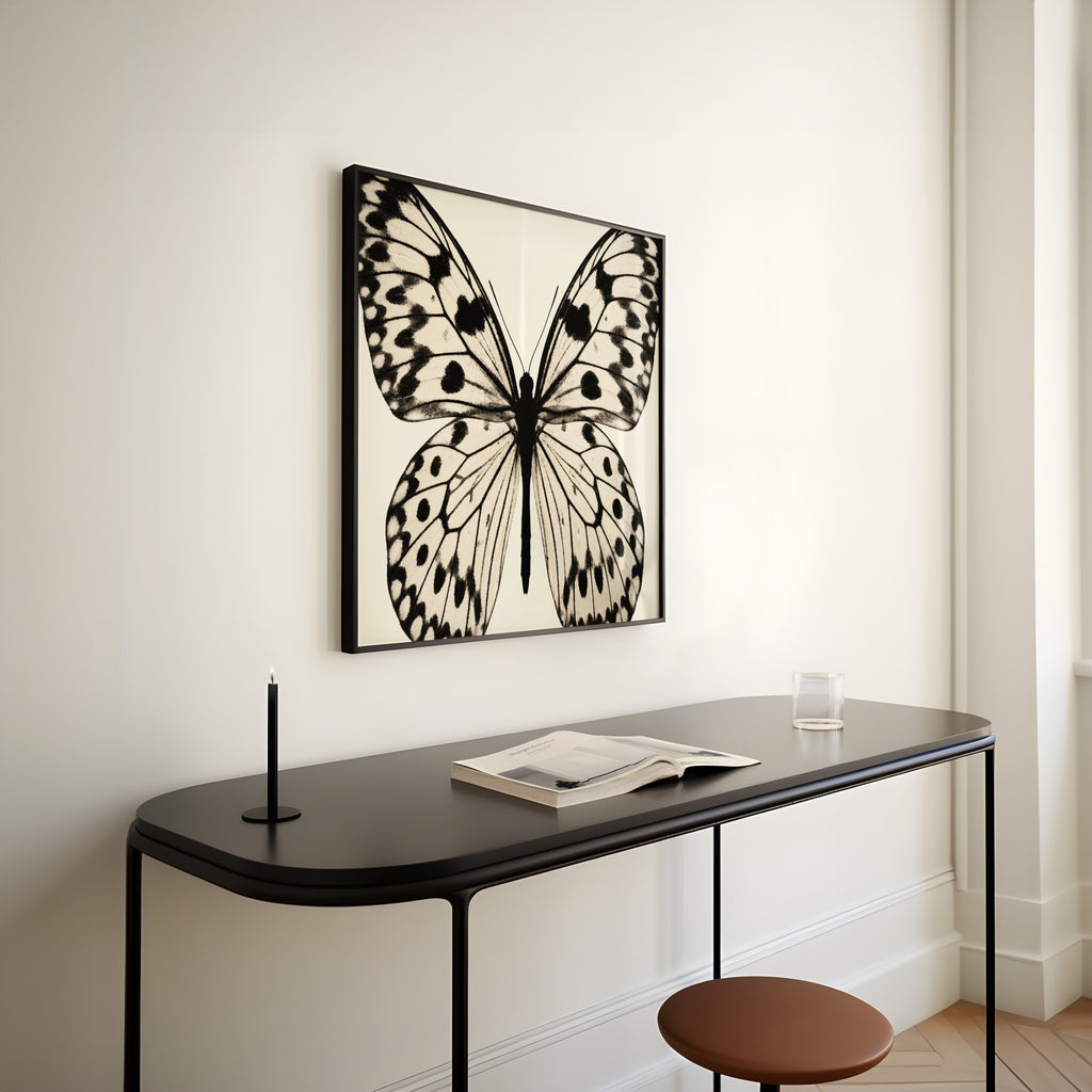 square framed butterfly black and white print hanging above metal console in entryway