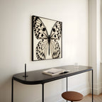 square framed butterfly black and white print hanging above metal console in entryway