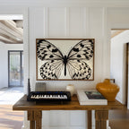 framed black and white poster print hanging in entryway over wooden table with decor and keyboard