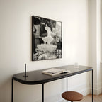 square framed black and white wall art hanging in entryway above black modern console table