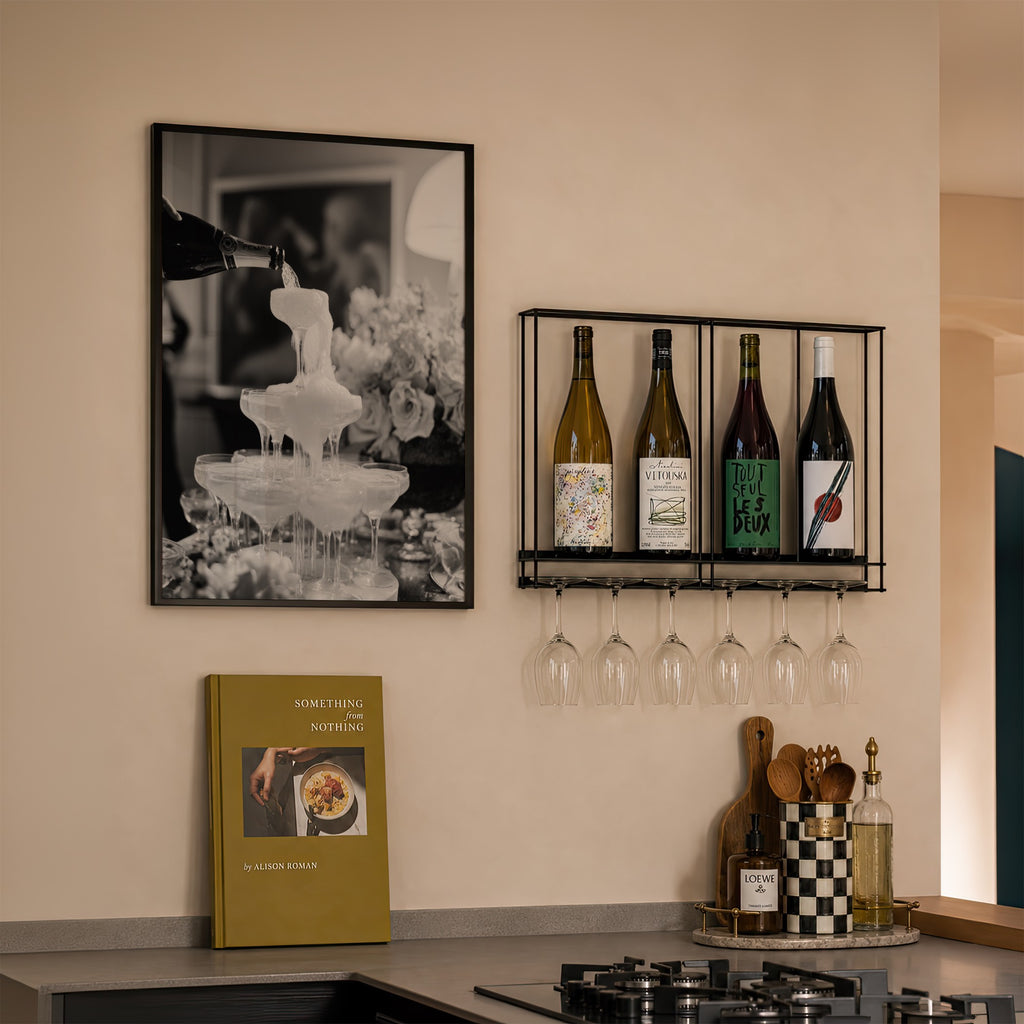 framed champagne showers black and white poster print hanging in kitchen next to wine rack above cook book