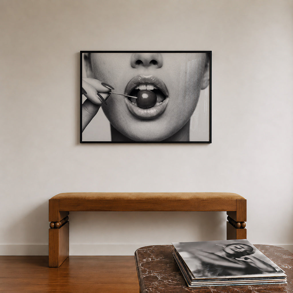 framed black and white poster print of cherry bomb, cherry between woman's lips framed hanging above console in entry way