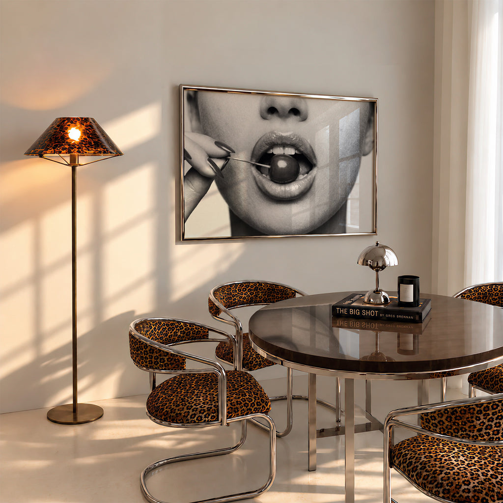 black and white poster print of cherry bomb, cherry between woman's lips framed hanging above table in dinging room with cheetah accents
