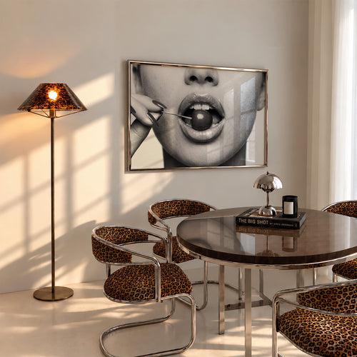 black and white poster print of cherry bomb, cherry between woman's lips framed hanging above table in dinging room with cheetah accents
