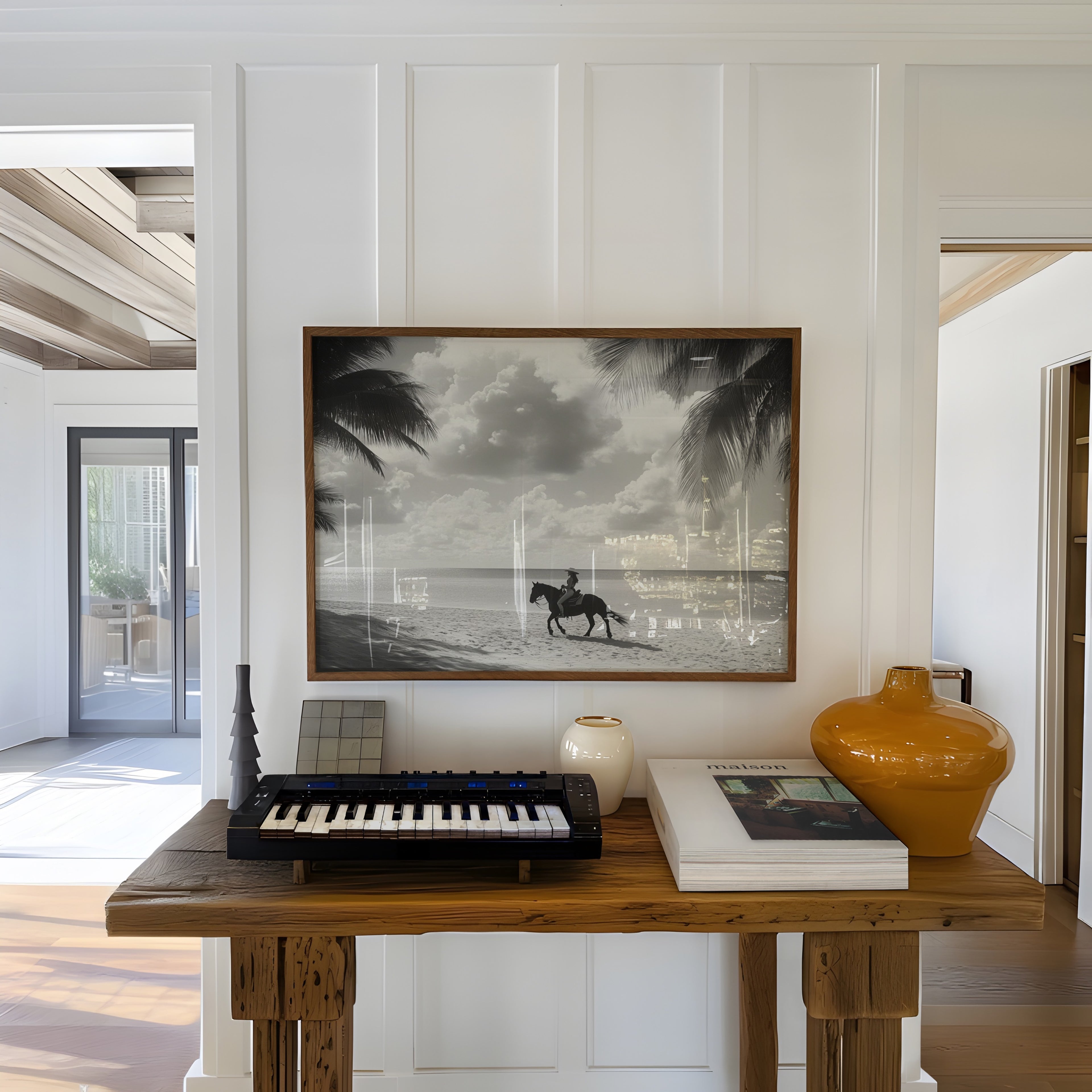 Wooden table with keyboard, books, and vases in a room with coastal cowgirl black and white wall art on wall
