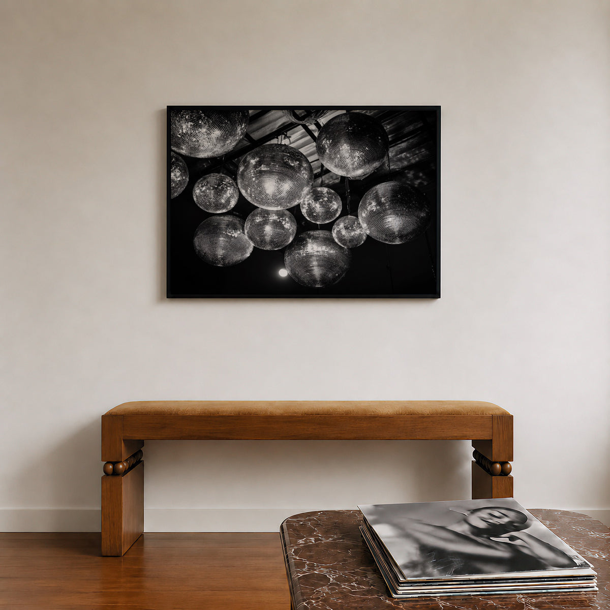 framed black and white disco ball poster print hanging in entryway above decorative bench