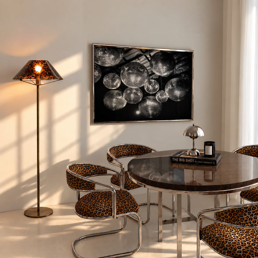 framed black and white disco ball poster print hanging above table in dining room with cheetah accents