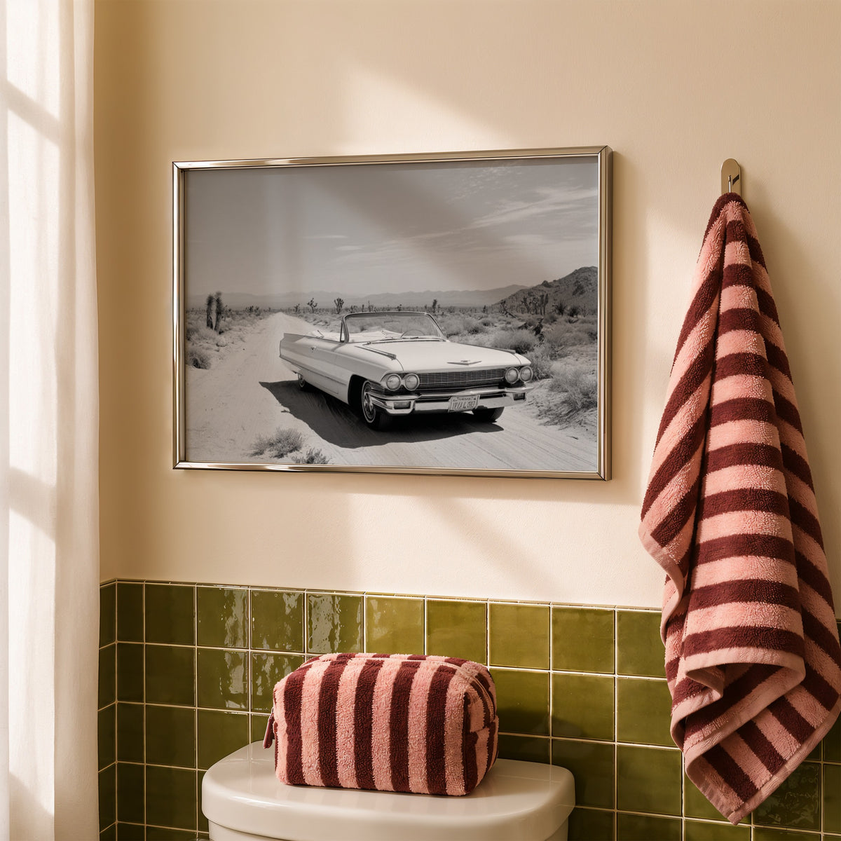 framed black and white Dust & Dreams poster print wall art hanging above toilet in bathroom next to red stripped bag and towel and green tile
