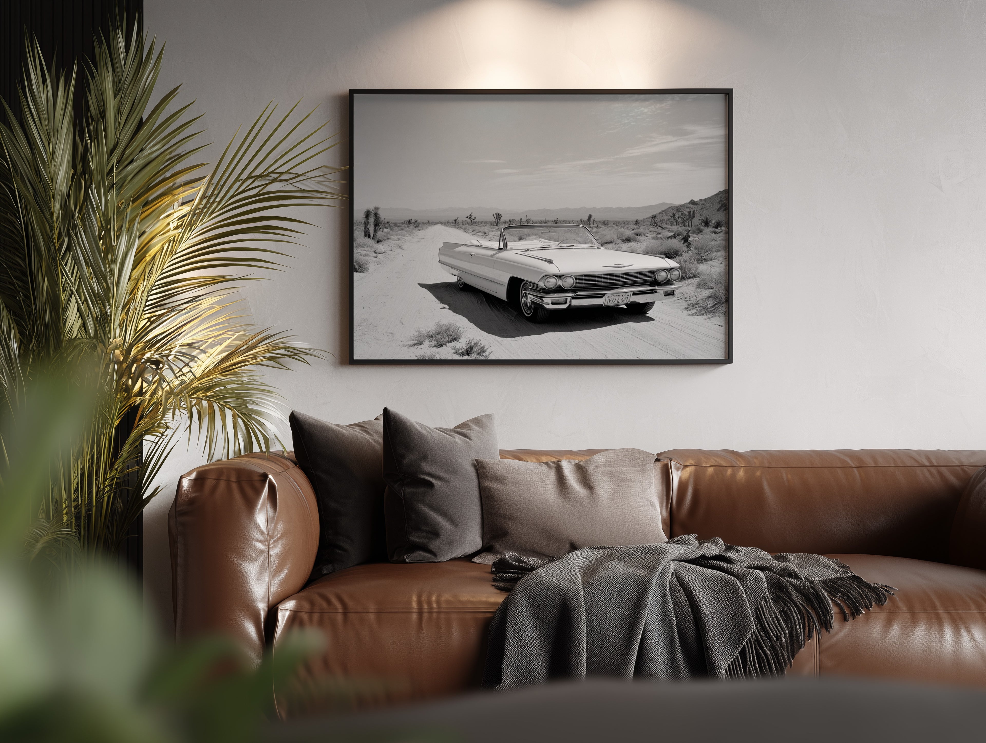 Brown leather sofa with cushions and a blanket in a living room setting, featuring a Framed black and white dust and dreams wall art  hanging on the wall