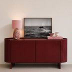 framed black and white dolphin print sitting on red console in entryway with pink decor