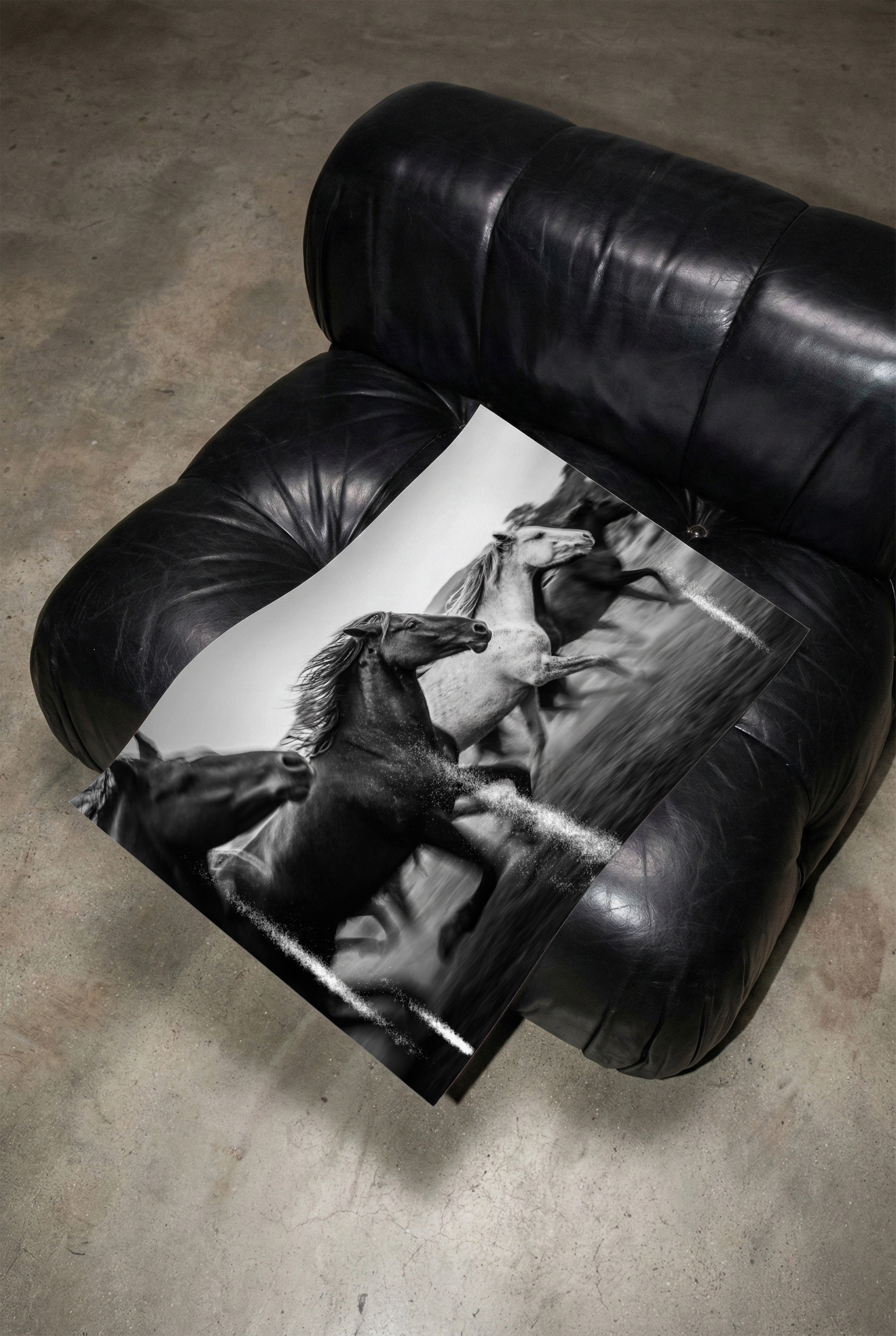 Black leather armchair with Framed black and white freedom poster print on its seat.