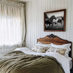 Farmhouse Bedroom with wooden headboard, floral pillows, and Framed black and white freedom poster print above bed