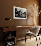 Modern home office with wooden desk, chair, lamp, and Framed black and white freedom wall art