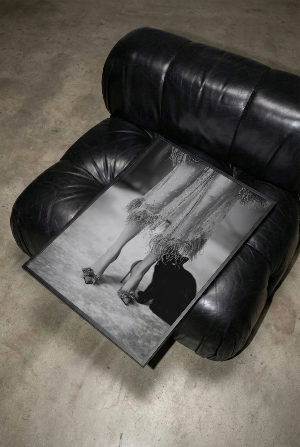 Black leather armchair with framed black and white kitty kitty glam room wall art sitting on top