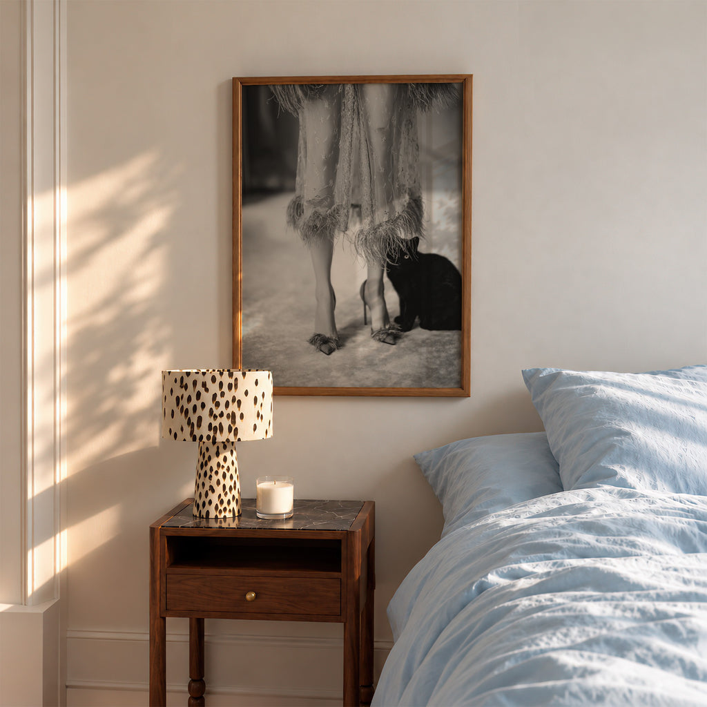 framed kitty kitty black and white poster print hanging above night stand in bedroom