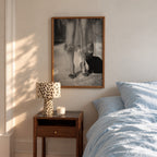 framed kitty kitty black and white poster print hanging above night stand in bedroom