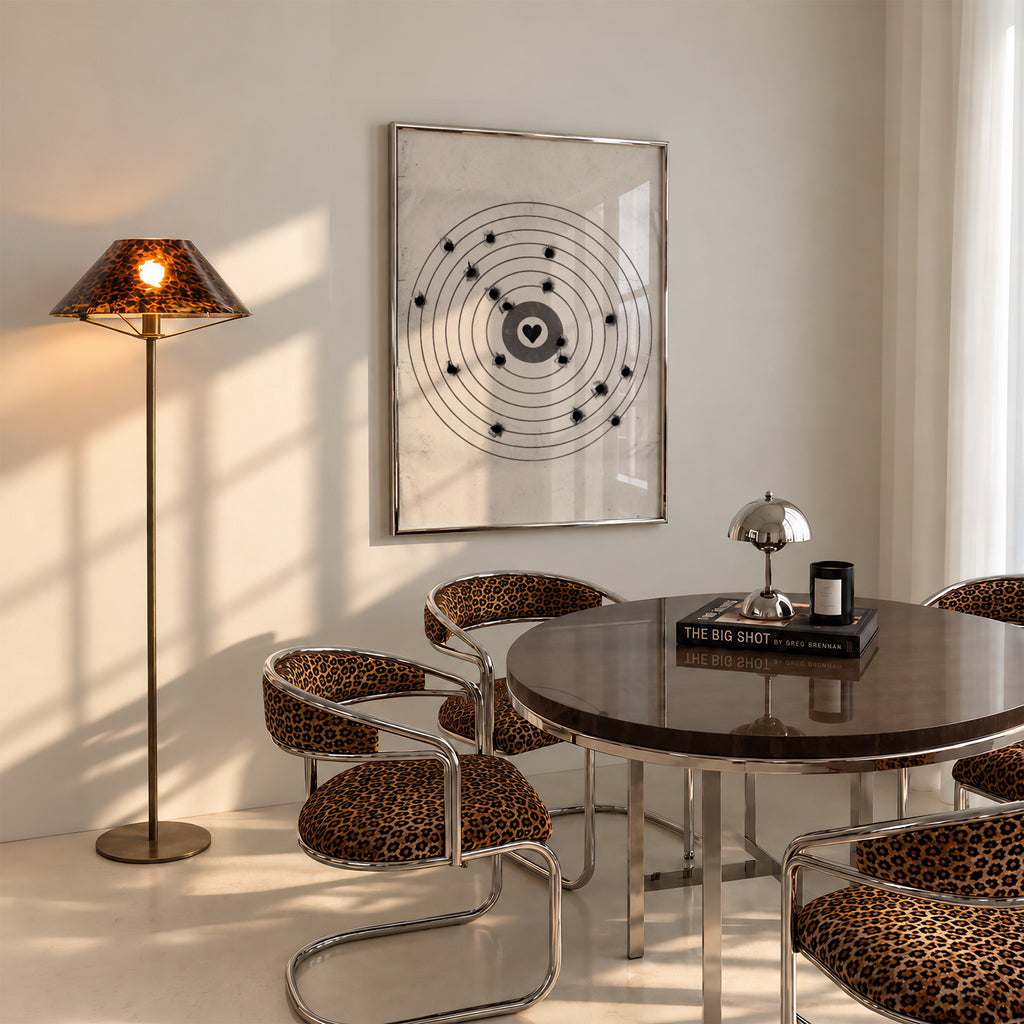A framed moving target wall art print featuring a black bullseye with a heart at the center hanging in dining room over table
