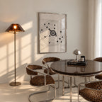 A framed moving target wall art print featuring a black bullseye with a heart at the center hanging in dining room over table