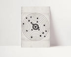 A square wall art print or canvas featuring a black atomic model design with a heart-shaped center on a light gray textured background, displayed against a white wall.