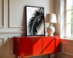 framed black and white paradise palm wall art poster print sitting on red console as entryway decor