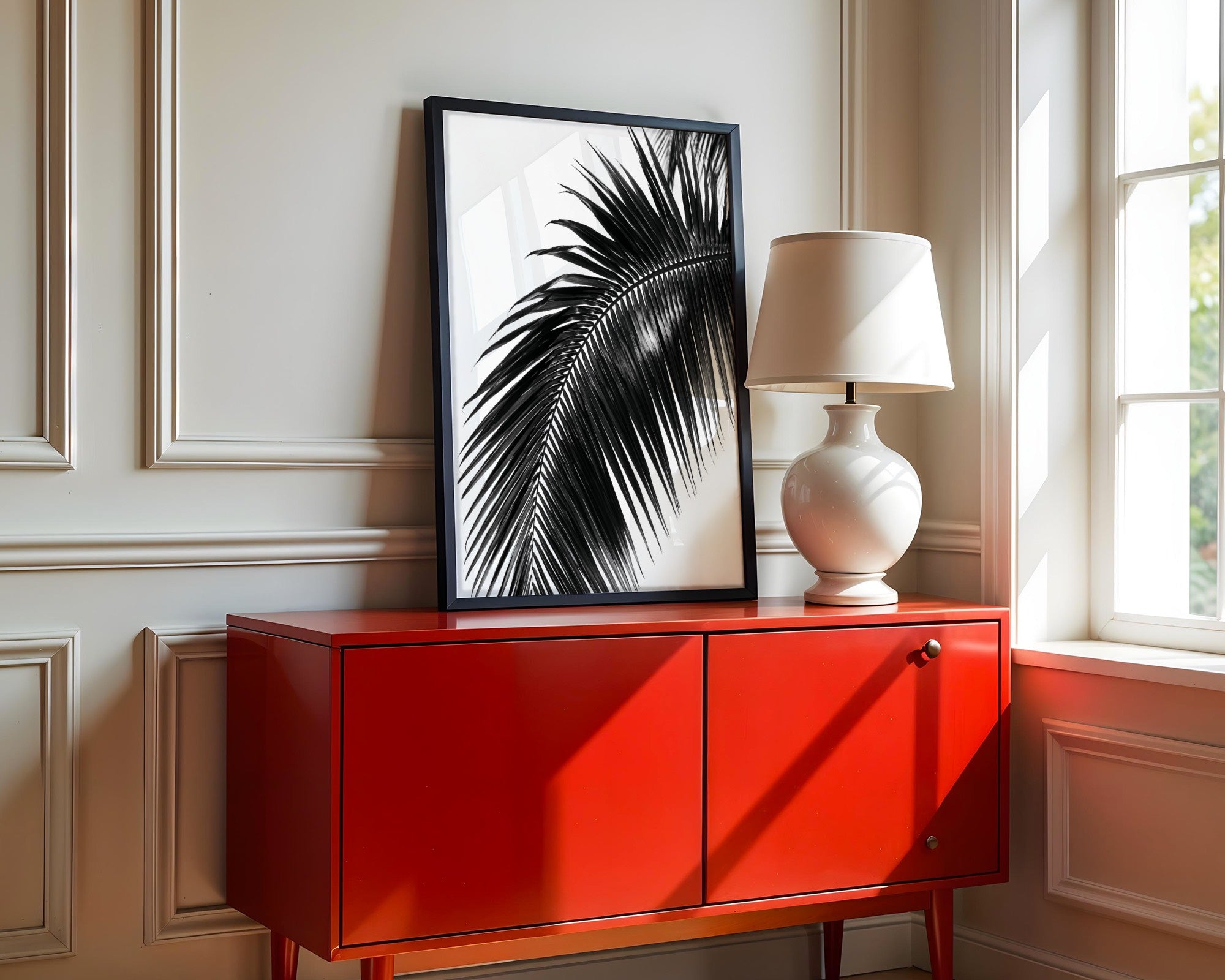 framed black and white paradise palm wall art poster print sitting on red console as entryway decor