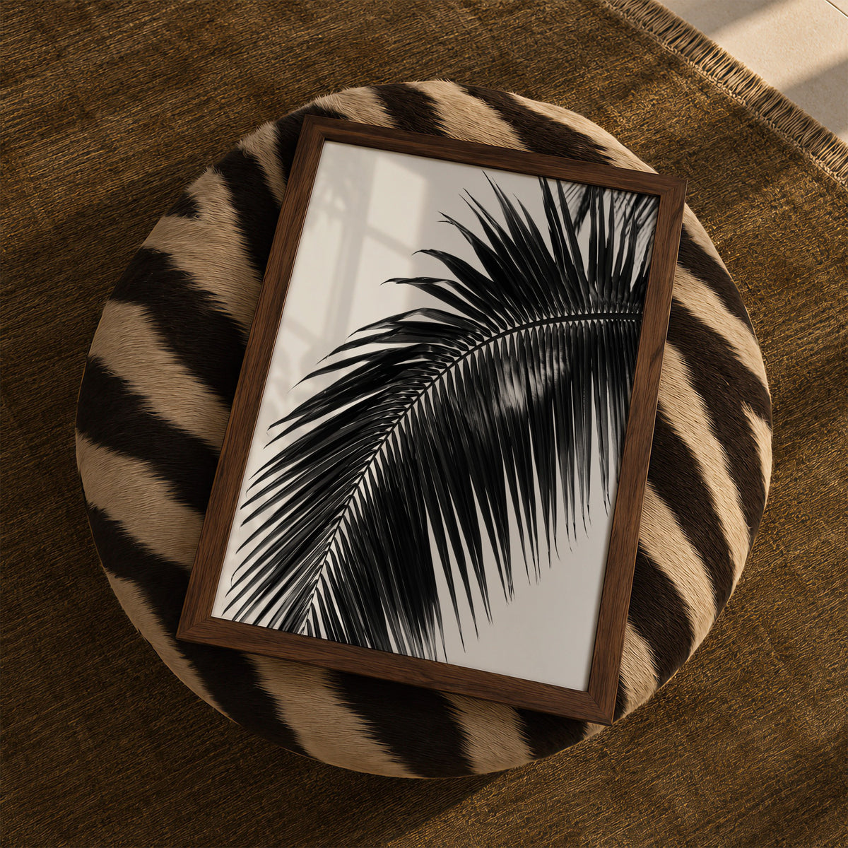 framed black and white paradise palm print sitting on zebra ottoman