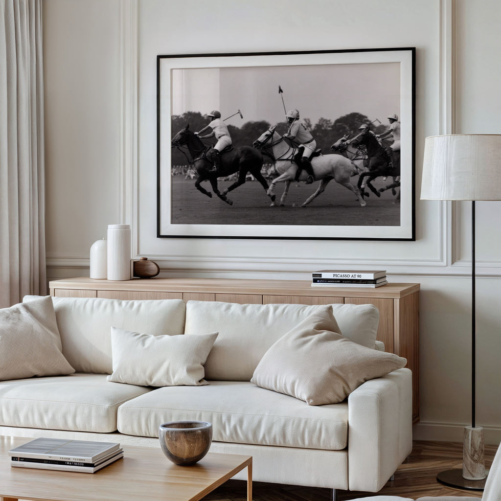 Living room with a white sofa, wooden coffee table, and large framed black and white polo club wall art print on the wall