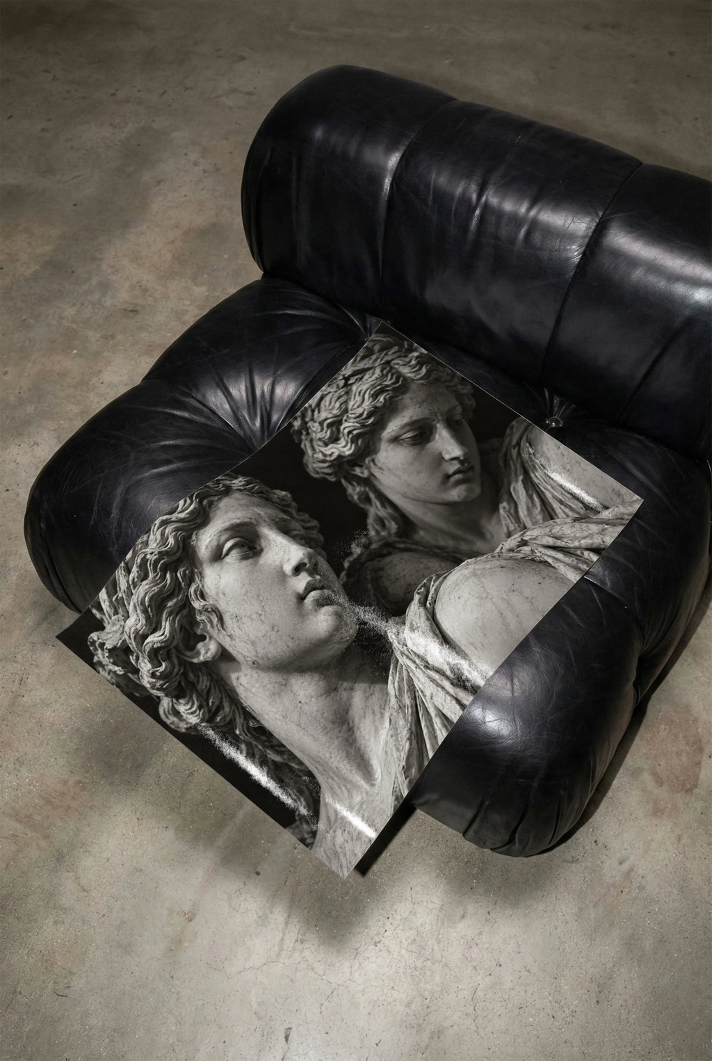 black and white marble statue poster print unframed laying on black leather chair