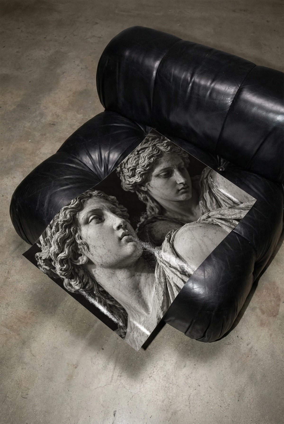 black and white marble statue poster print unframed laying on black leather chair