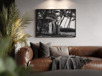 Brown leather sofa with decorative pillows and a blanket in a living room setting, featuring a Framed black and white Surfs Up poster print  on the wall.